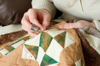 A young woman's hands quilting